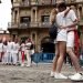 Una pareja se besa mientras un grupo de personas se toman una fotografía con la fachada del Ayuntamiento de Pamplona de fondo este martes 6 de julio, cuando debería lanzarse el tradicional chupinazo que diera inicio a las fiestas de San Fermin 2021 suspendidas por segundo año consecutivo por la pandemia de coronavirus. Foto: Jesús Diges / EFE.