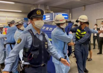 La policía escolta a rescatistas que llevan a una persona herida después de un ataque con cuchillo en un tren en Tokio. Foto: Al Jazeera.