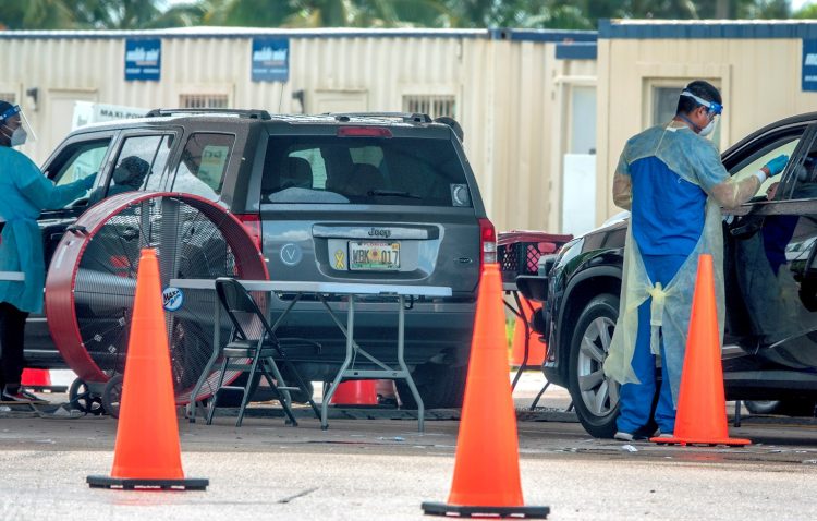 Trabajadores sanitarios hacen test diagnósticos de la COVID-19 a conductores en sus autos en el Tropical Park en Miami, Florida. Foto: Cristobal Herrera-Ulashkevich / EFE.