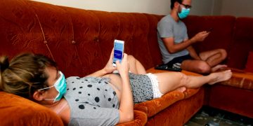 Una pareja revisa sus teléfonos celulares dentro de su casa durante la cuarentena por la pandemia de COVID-19 en La Habana. Foto: Ernesto Mastrascusa / EFE / Archivo.