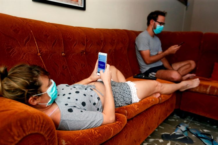 Una pareja revisa sus teléfonos celulares dentro de su casa durante la cuarentena por la pandemia de COVID-19 en La Habana. Foto: Ernesto Mastrascusa / EFE / Archivo.