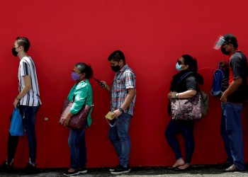 Un grupo de personas en fila antes de ser vacunados contra la COVID-19, en el estacionamiento del estadio Rommel Fernández, en Ciudad de Panamá (Panamá). Foto: EFE/Bienvenido Velasco/Archivo.