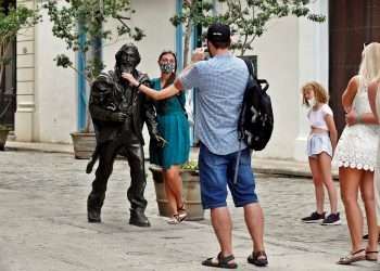 Turistas se toman fotos junto a la escultura del Caballero de París, en La Habana Vieja. Foto: Ernesto Mastrascusa / EFE / Archivo.