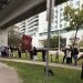 Personas esperan en una fila su turno en un punto de pruebas rápidas de Covid-19 instalado bajo la vía de un tren elevado en el barrio de Brickell en Miami (EEUU), este 27 de diciembre de 2021. Foto: Ana Mengotti/EFE.
