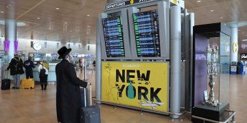 Un pasajero judío ultraortodoxo mira el tablero de salidas en el Aeropuerto Internacional Ben Gurion cerca de Tel Aviv, Israel, el 20 de diciembre de 2021. Foto: Abir Sultan / EFE.