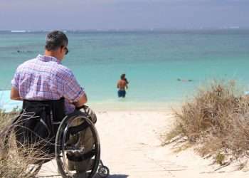 Persona con discapacidad disfruta de una playa como turista. Foto: Organización Mundial de Turismo.