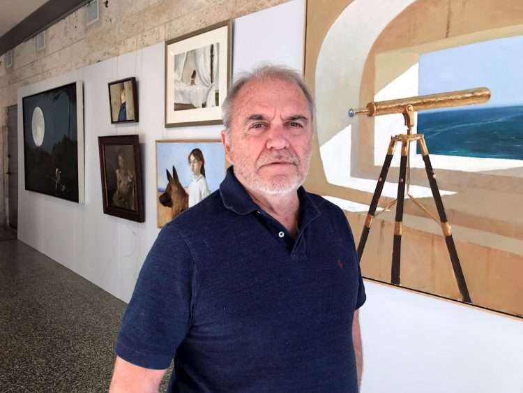 El artista de la plástica de origen cubano, Julio Larraz, posa junto a unas de sus pinturas el 26 de noviembre durante una entrevista con Efe en el Museo de Coral Gables, ciudad aledaña a Miami, Florida (EEUU). Foto: Ana Mengotti/Efe.