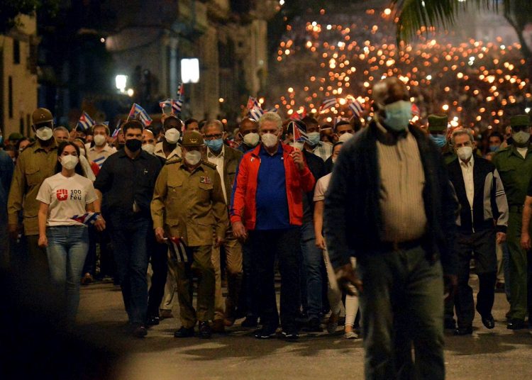 El presidente cubano, Miguel Diaz-Canel (c-d), junto al general de Ejército Raúl Castro (c-i), participan en la tradicional Marcha de las Antorchas, en La Habana. Foto: Felipe Borrego/Efe.