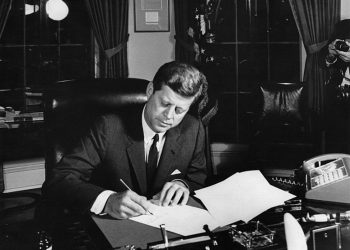 El presidente Kennedy firma la Proclamación 3504 autorizando la cuarentena naval de Cuba (23 de octubre de 1962), a ocho meses del anuncio del embargo y en plena Crisis de los Misiles en Cuba. Foto: Abbie Rowe. Fotografías de la Casa Blanca. Biblioteca y Museo Presidencial John F. Kennedy, Boston