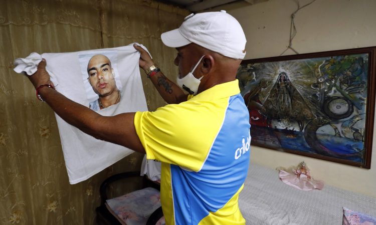 Omar Quintero, el cubano conocido como "el pagador de promesas", muestra la imagen de su hijo enfermo impresa en una camiseta durante una entrevista en La Habana. Foto: Ernesto Mastrascusa / EFE.