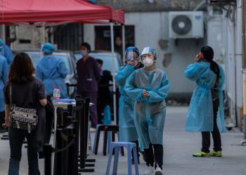 Personal médico trabaja en un sitio de pruebas para detectar la COVID-19 en un complejo residencial, en Shanghái, China, 13 de marzo de 2022. Foto: Alex Pavlevski / EFE.