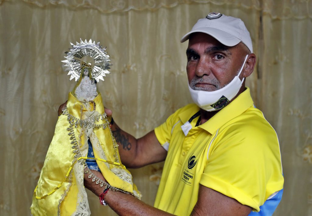 Omar Quintero, el Pagador de Promesas Cubano, muestra la Virgen de La Caridad, la cual lo acompañó durante su recorrido hasta el Santuario del Cobre, en Santiago de Cuba. Foto: Ernesto Mastrascusa / EFE.