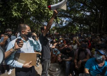 Un funcionario panameño da información a cientos de personas que aguardan para resolver su situación frente a la Embajada de Panamá, en La Habana, este 9 de marzo de 2022. Foto: Yander Zamora / EFE.