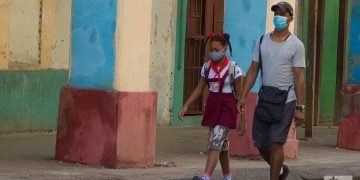 Un hombre lleva a su hija a la escuela, en La Habana. Foto: Otmaro Rodríguez.