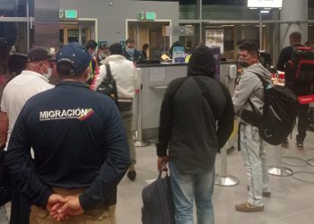 Un oficial de la autoridad migratoria mientras acompaña a un grupo de ciudadanos cubanos en el Aeropuerto Internacional El Dorado de Bogotá (Colombia). Foto: Migración Colombia /Efe.