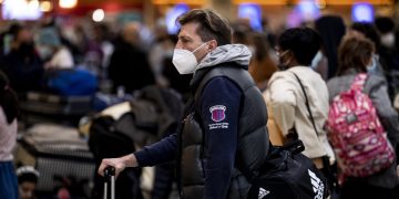 Pasajeros se protegen con mascarillas en el Aeropuerto Internacional de Los Ángeles, Estados Unidos. Foto: Etienne Laurent /EFE.