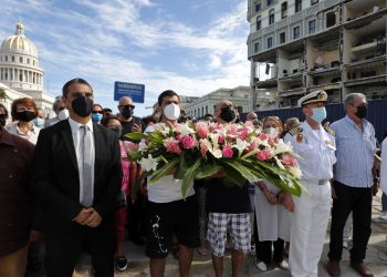 El embajador de España en Cuba, Ángel Martín Peccis (i), el capitán de navío Manuel García Ruiz (2-d), y representantes de las diferentes sociedades españolas en Cuba, colocan una ofrenda floral frente al Hotel Saratoga, en La Habana, el lunes 16 de mayo de 2022. Foto: Ernesto Mastrascusa / EFE.