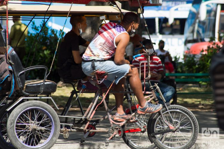 Un conductor de bicitaxi viste una camiseta con la bandera de Estados Unidos, en La Habana, el martes 17 de mayo de 2022. Foto: Otmaro Rodríguez.