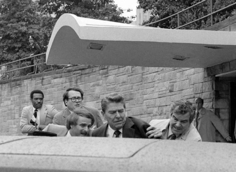 Instante en que el ex presidente Ronald Reagan era empujado hacia dentro de la limusina tras los disparos. Foto: Ron Edmonds / AP (Archivo).