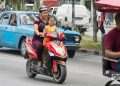 Una madre y su hija sin nasobuco en una moto eléctrica en La Habana, el martes 31 de mayo de 2022, tras la eliminación del uso obligatorio de la mascarilla por las autoridades cubanas. Foto: Otmaro Rodríguez.