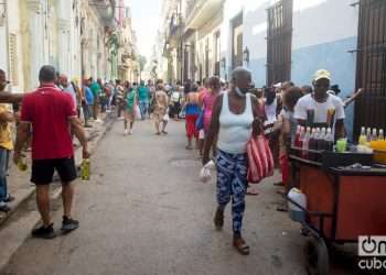 Personas caminan bajo el sol en una calle de La Habana, en sus actividades cotidianas. Foto: Otmaro Rodríguez.