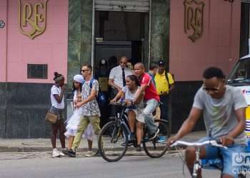 Personas se mueven bajo el sol en la calle Monserrate de La Habana, en los alrededores del célebre bar El Floridita. Foto: Otmaro Rodríguez.