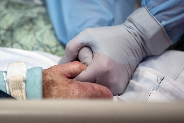 Imagen de archivo donde se ve a una enfermera que coge la mano de una paciente con coronavirus ingresada en la UCI de un hospital en Estados Unidos. Foto: EFE / Archivo.