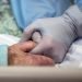 Imagen de archivo donde se ve a una enfermera que coge la mano de una paciente con coronavirus ingresada en la UCI de un hospital en Estados Unidos. Foto: EFE / Archivo.