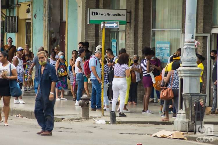 Personas en las afueras de un banco, en la calle Galiano de La Habana, un día después del anuncio por las autoridades de un nuevo mercado cambiario en la Isla. Foto: Otmaro Rodríguez.