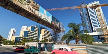 Autos pasan junto a hoteles en construcción y otros ya abiertos, en La Habana, en agosto de 2022. Foto: Ernesto Mastrascusa / EFE.