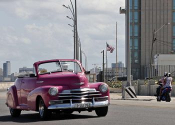 Un automóvil clásico pasa frente a la embajada de Estados unidos en La Habana. Foto: Ernesto Mastrascusa / EFE.