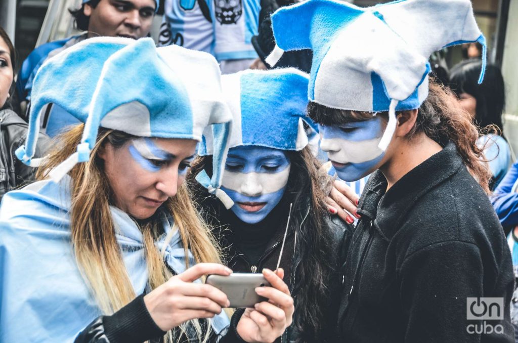 Hinchas de Argentina miran un partido de Mundial de Fútbol en el celular en Buenos Aires. Foto: Kaloian.
