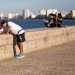 Personass se toman fotos selfie en el malecón de la Habana en 2022 Ciudad al fondo, mar. Foto: Jorge Ricardo