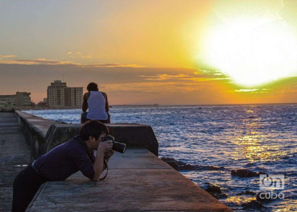 hombre sentado frente al mar fotografía puesta de sol malecón de la habana cuba foto de jorge ricardo