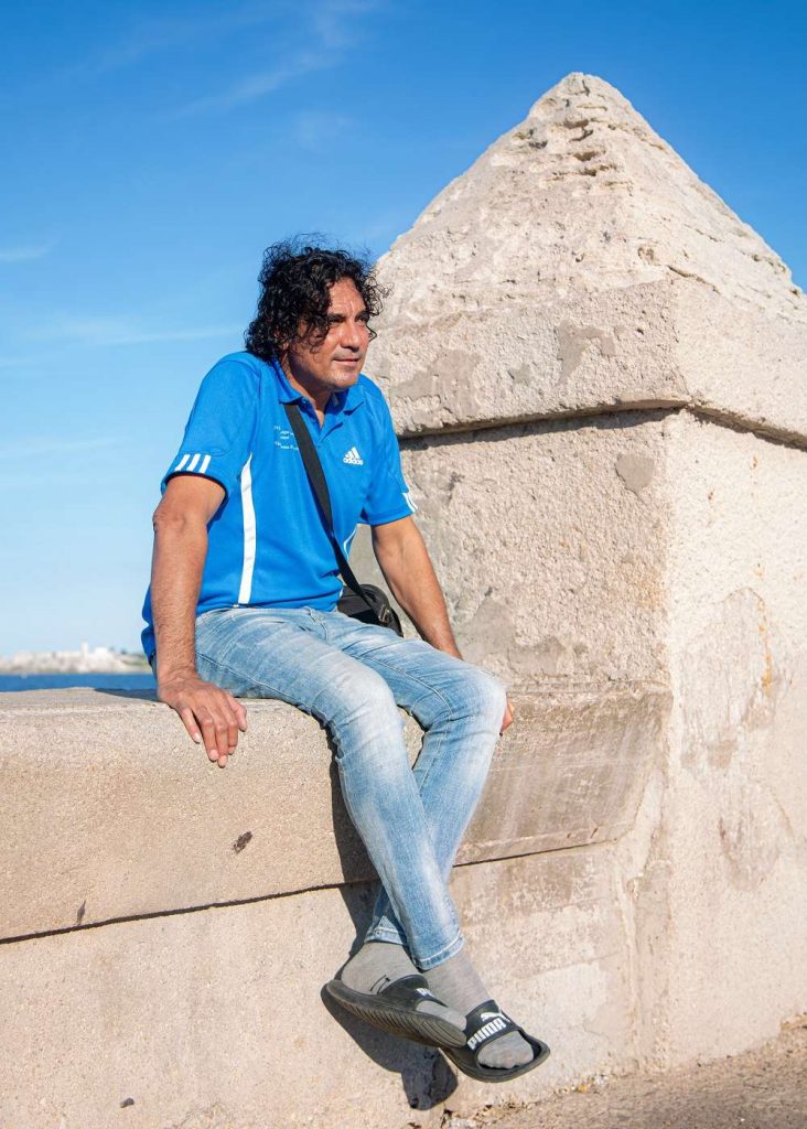 hombre de pelo negro sentado en el muro del malecón de la habana Foto Jorge Ricardo