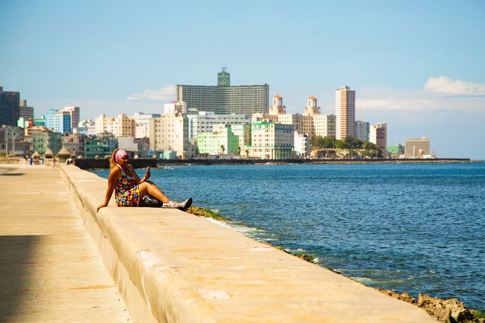 mujer sentada frente al mar en el malecon de la habana foto jorge ricardo