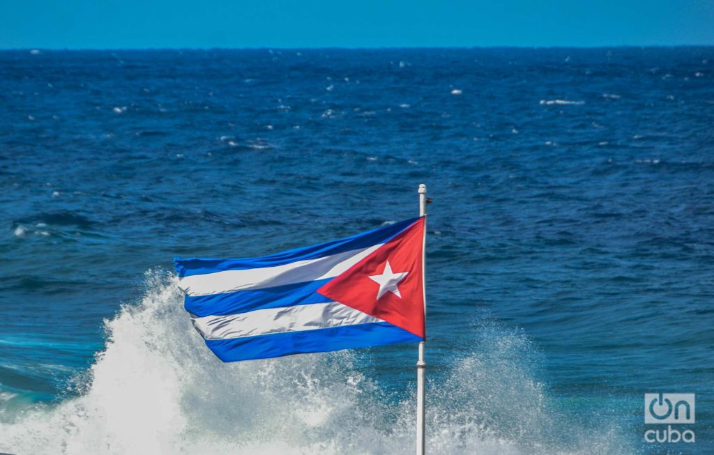 Bandera cubana a las olas del mar en el Malecón de la Habana foto: Kaloian
