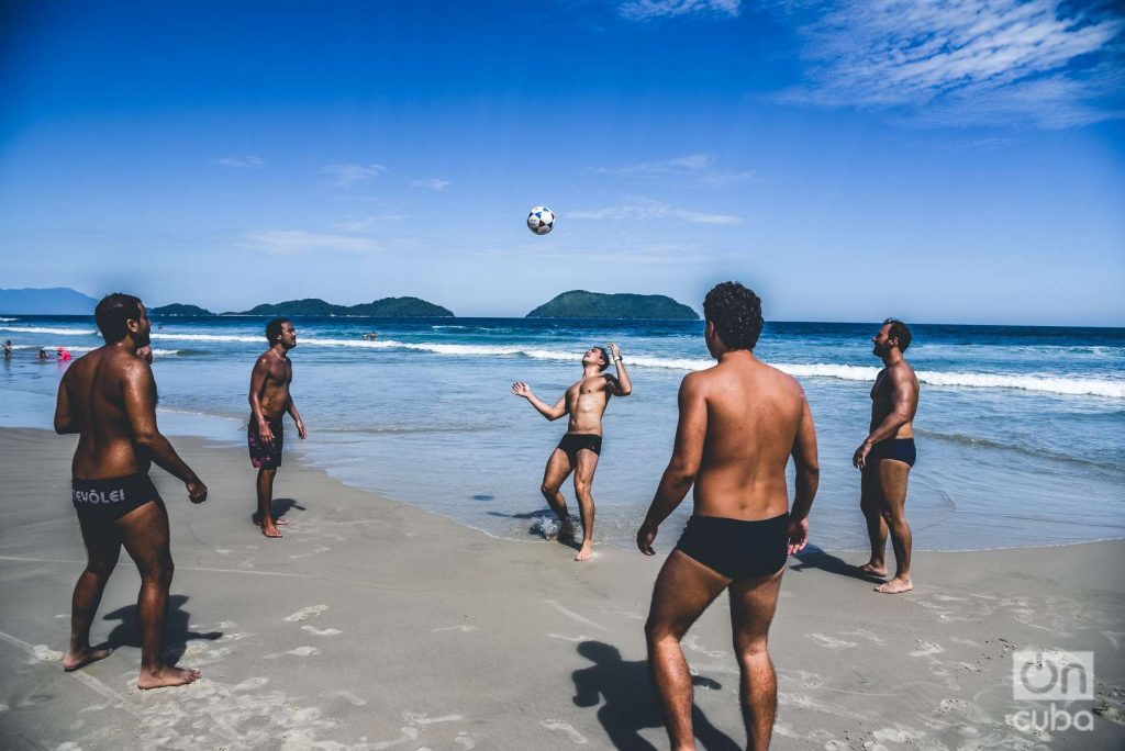 grupo de amigos juegan al fútbol en una playa de Sao Pablo, Brasil.
