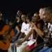 Grupo de personas en el muro del malecón de la Habana escucha a un músico aficionado con su guitarra de noche. Foto: Jorge Ricardo