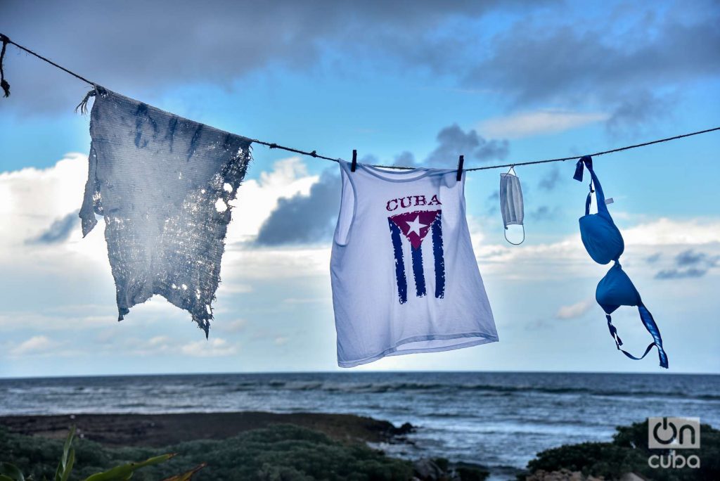 Ropa tendida, bandera cubana, mascarilla, ajustadores con el mar de fondo Foto: Kaloian.