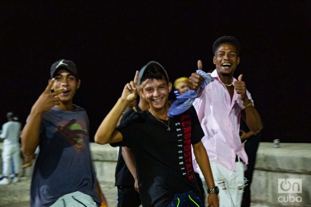 Adolescentes hacen signo de victoria en el malecón de la habana de noche 2022 foto Jorge Ricardo