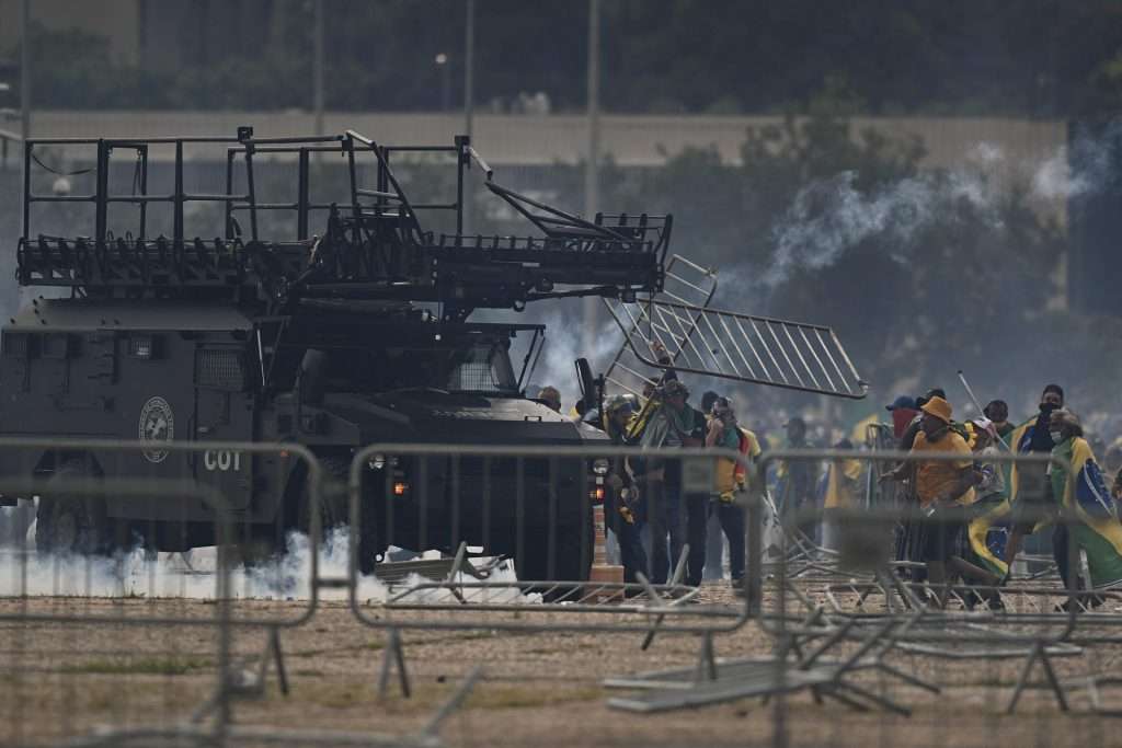 Decenas de agentes subieron la rampa que da acceso a la primera planta del palacio disparando gases lacrimógenos, mientras otro grupo de uniformados rodeaba el edificio. Foto: EFE/ Andre Borges.