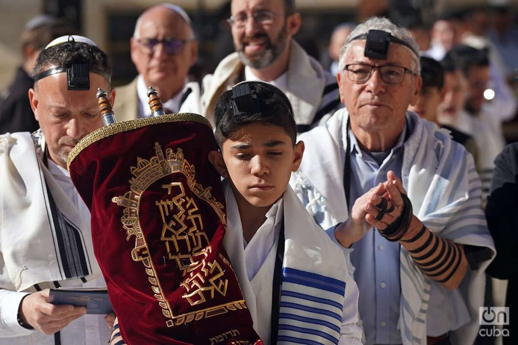 Adolescente en su Bar Mitzvah rodeado de otros judíos. Foto: Alejandro Ernesto.