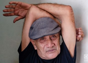 el poeta cubano Delfín Prats con los brazos cruzados en alto. Holguín, Kaloian.