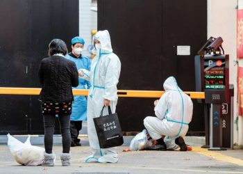 Trabajadores de la salud dirigen a personas que dieron positivo por coronavirus al área de cuarentena, en Shanghái, China. Foto: EFE.