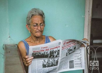 Anciana lee el periódico Granma en La Habana, Cuba Foto Kaloian