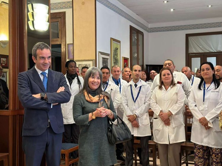 La embajadora cubana, Mirta Granda (segunda, iz), el presidente de la región de Calabria, Roberto Occhiuto (izq) junto al contingente de 51 médicos cubanos que viajarán a la región italiana de Calabria para ayudar a solucionar su crisis sanitaria. Foto: Embajada de Cuba en Roma/Efe.