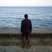 Hombre mira al mar en el muro del malecón de La Habana. Foto: Alejandro Ernesto.