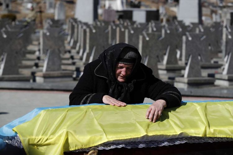 La madre del oficial del ejército ucraniano Ivan Skrypnyk, muerto en acción el 13 de marzo, recostada sobre el ataúd de su hijo durante un funeral en el cementerio militar de Lviv, Ucrania, 17 de marzo de 2022. Foto: EFE/EPA/ATEF SAFADI.