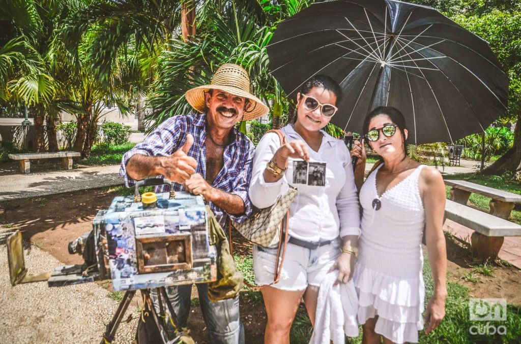 Del Toro con un sombrero para protegerse del sol de Cuba, junto a clientas satisfechas. La Habana, 2019. Foto: Kaloian.